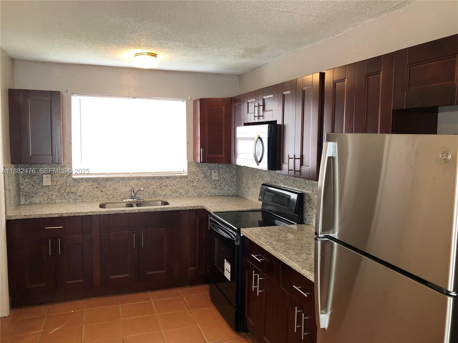 10250 Southwest 172nd Street Miami, FL 33157 - Photo 29 of 39 a kitchen with a refrigerator sink and stove