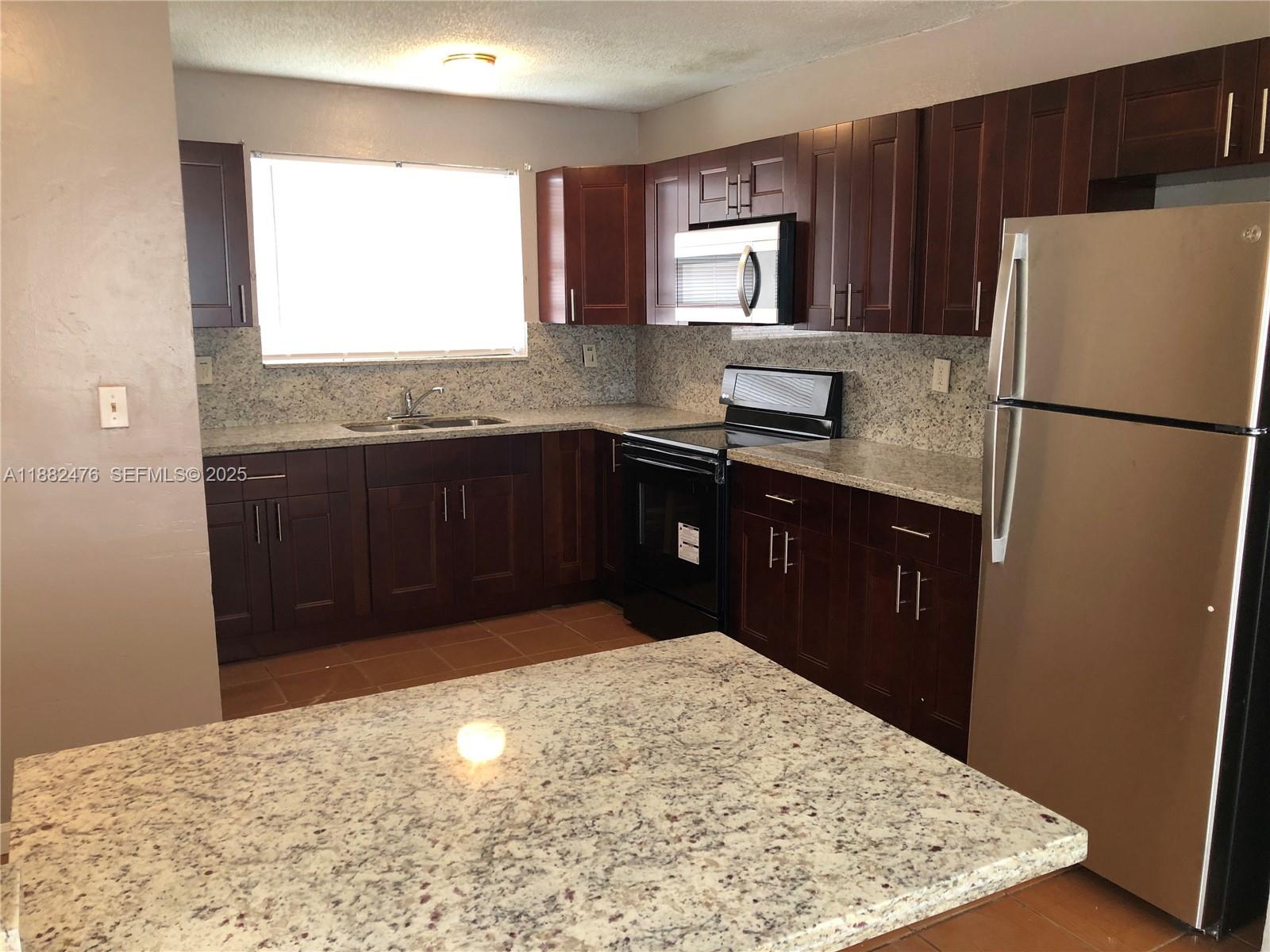 10250 Southwest 172nd Street Miami, FL 33157 - Photo 3 of 39 a kitchen with a refrigerator and a sink