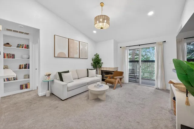 a living room with furniture a flat screen tv and a large window