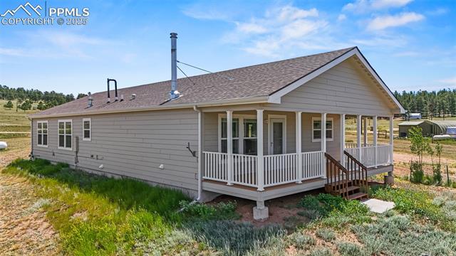 567 High Pasture Road Florissant, CO 80816 - Photo 35 of 48 Side view of house with a covered porch and a shingled roof