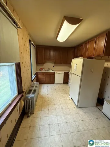 a view of kitchen with refrigerator cabinets and furniture