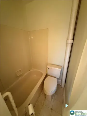 a white toilet sitting next to a bath tub