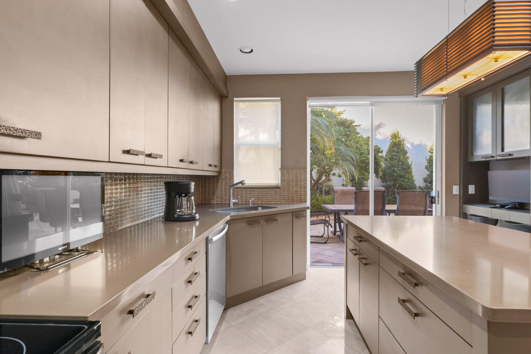 2595 Northwest 53rd Street Boca Raton, FL 33496 - Photo 7 of 48 a kitchen with a sink stove and cabinets