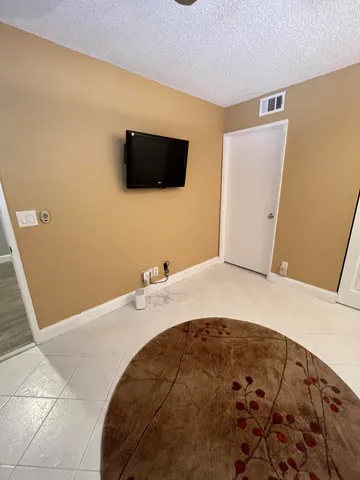 a bathroom with a granite countertop sink a toilet a mirror and shower