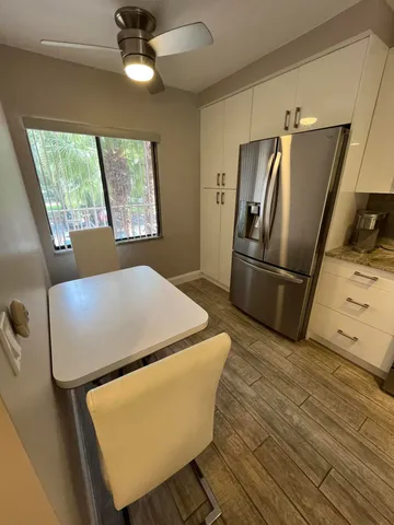 a bed sitting in a kitchen next to a window