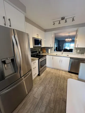 a kitchen with stainless steel appliances a refrigerator sink and microwave