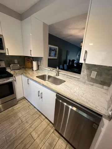 a kitchen with granite countertop a sink stove and cabinets