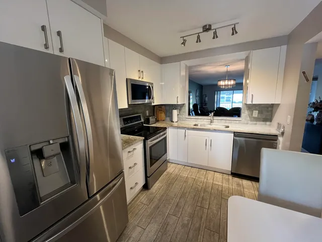 a kitchen with stainless steel appliances a refrigerator sink and microwave