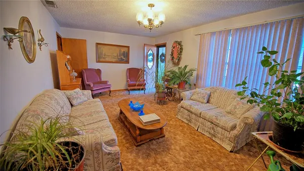 a living room with furniture flowers and a chandelier