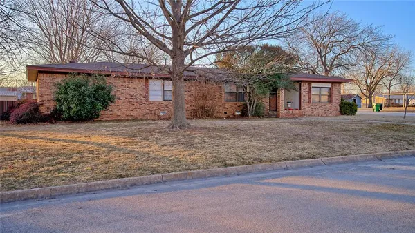 a front view of a house with a yard and trees