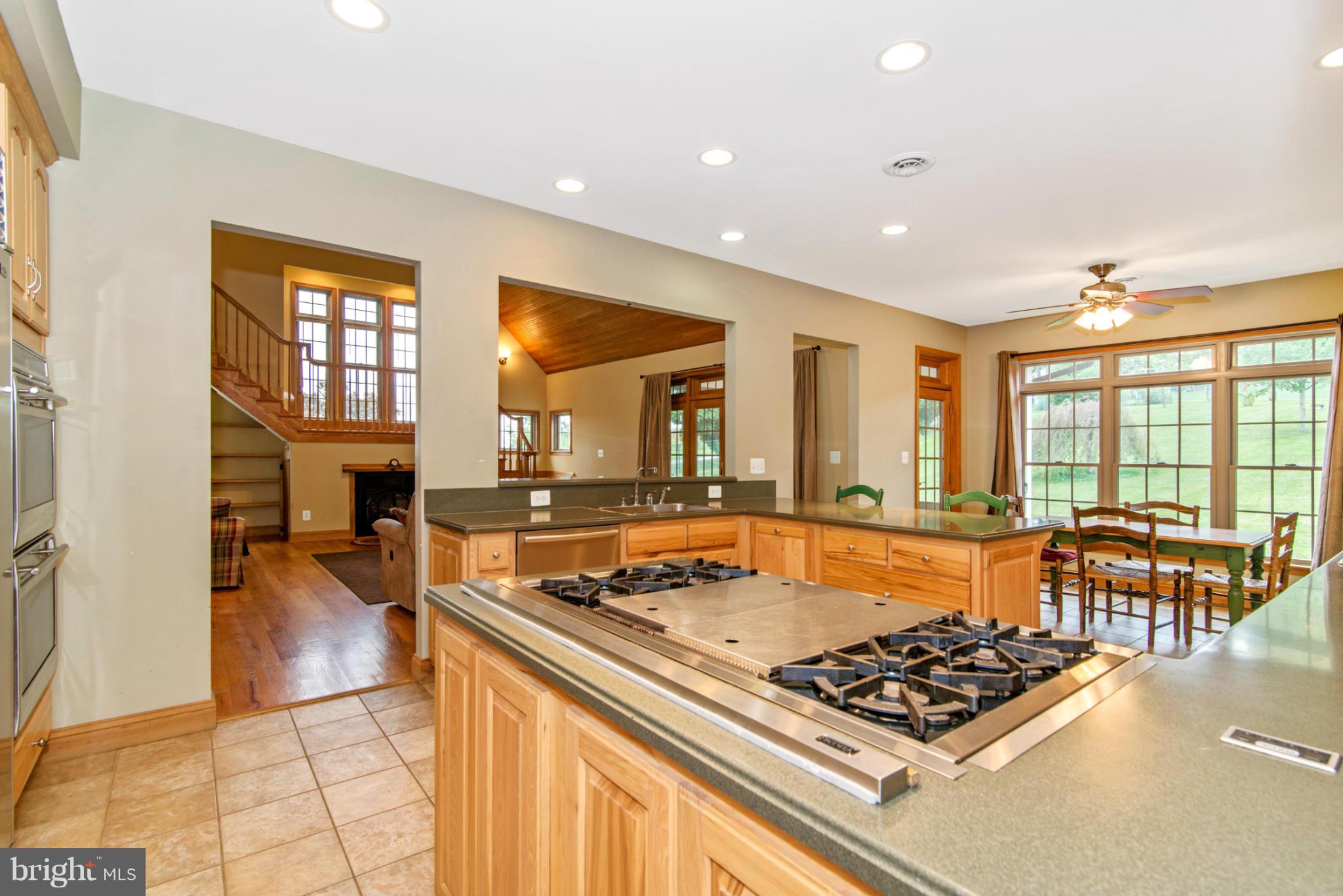 7728 Marker Road Middletown, MD 21769 - Photo 8 of 30 a kitchen with stainless steel appliances granite countertop a stove top oven a dining table and chairs with wooden floor