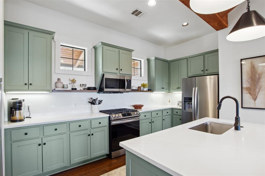 18852 Hidden Ridge Place Jonestown, TX 78645 - Photo 8 of 29 a kitchen with a sink a stove a refrigerator and cabinets