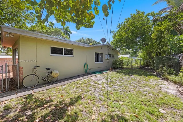 a view of a yard with plants and trees