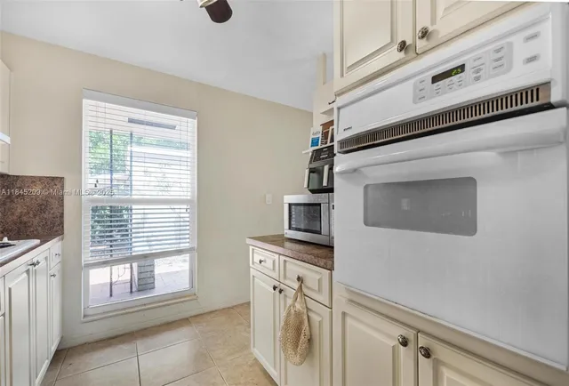 a kitchen with stainless steel appliances white cabinets and a window