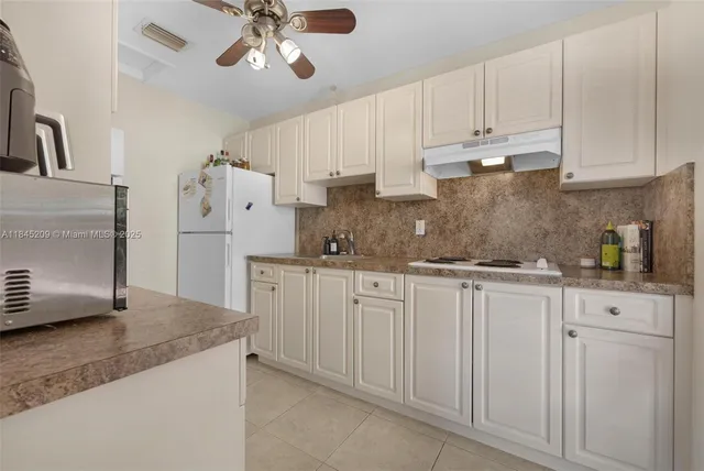 a kitchen with granite countertop a sink stainless steel appliances and white cabinets