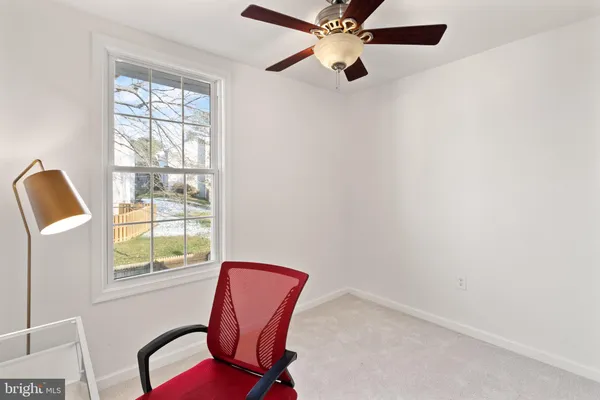 a view of a workspace with furniture and a window