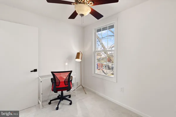 a view of a workspace with furniture and a window