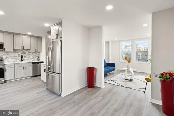 a kitchen with stainless steel appliances a refrigerator and wooden floor