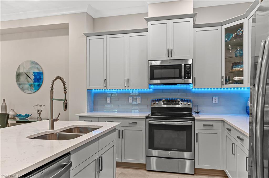 5827 Haiti Drive Naples, FL 34113 - Photo 11 of 29 a kitchen with granite countertop a sink stove and cabinets