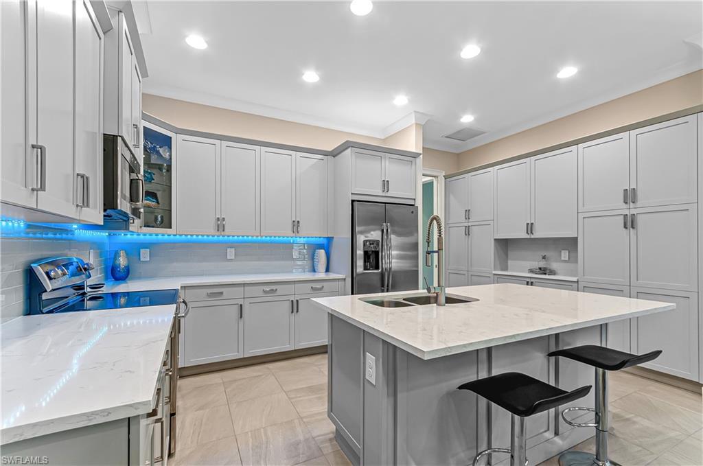 5827 Haiti Drive Naples, FL 34113 - Photo 13 of 29 a kitchen with a sink a stove a refrigerator and a stove