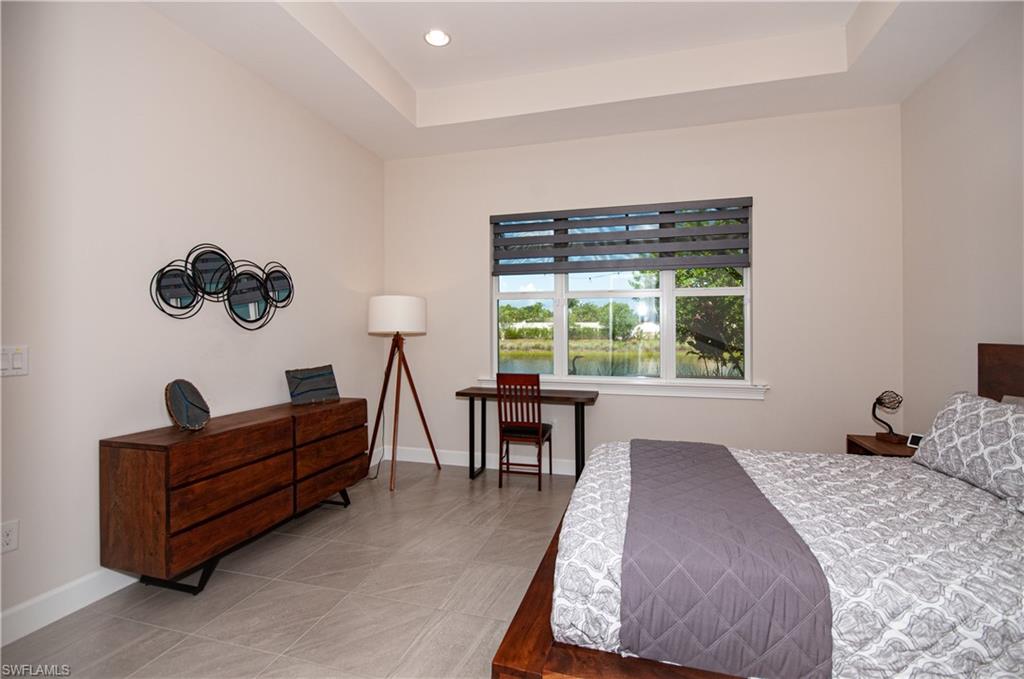 5827 Haiti Drive Naples, FL 34113 - Photo 16 of 29 a bedroom with a bed and a dresser next to a window