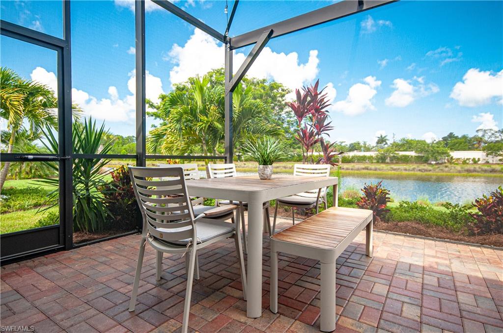 5827 Haiti Drive Naples, FL 34113 - Photo 22 of 29 a patio with water view and a dining table with chairs