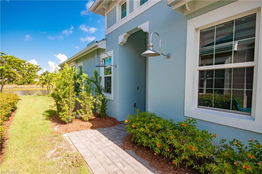5827 Haiti Drive Naples, FL 34113 - Photo 4 of 29 a front view of a house with a yard and flowers