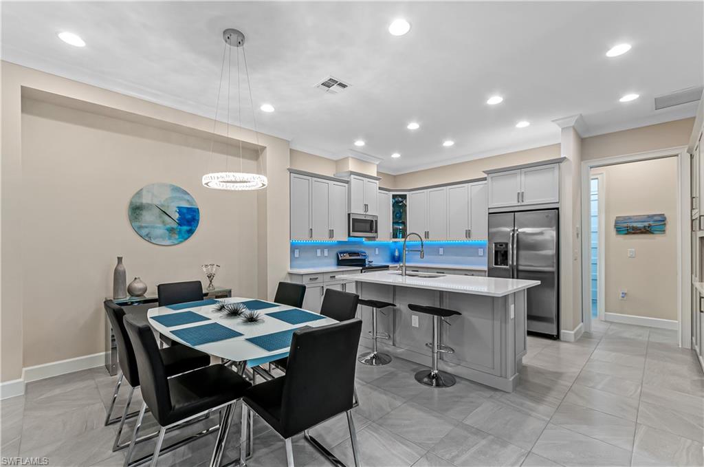5827 Haiti Drive Naples, FL 34113 - Photo 9 of 29 a kitchen with a dining table chairs and refrigerator
