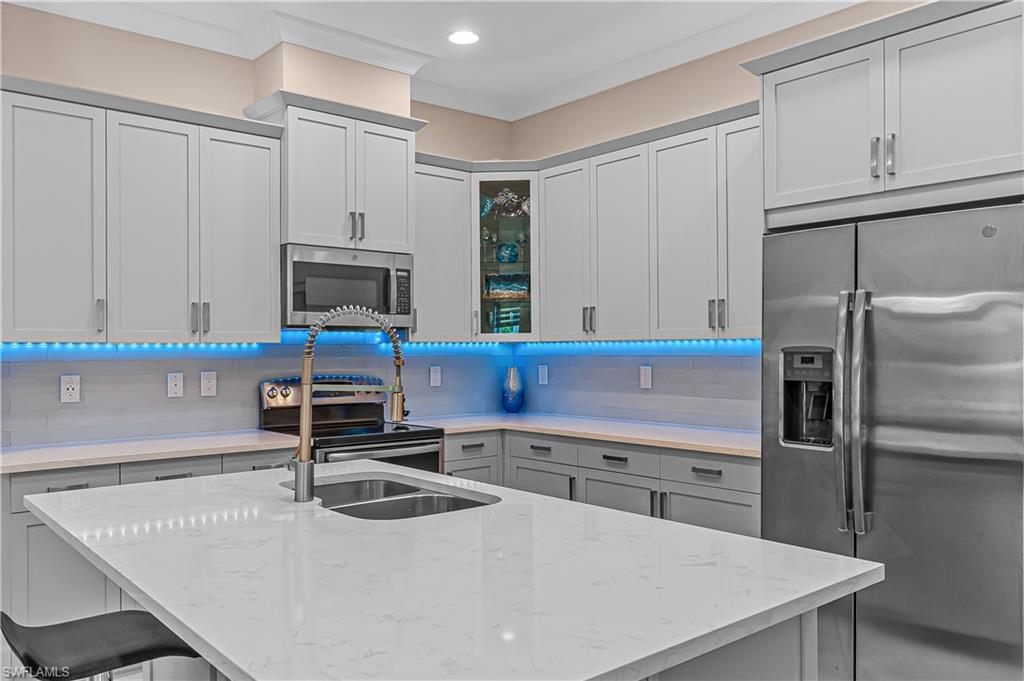 5827 Haiti Drive Naples, FL 34113 - Photo 10 of 29 a kitchen with kitchen island a sink stove and refrigerator