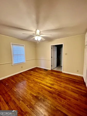 a view of empty room with wooden floor