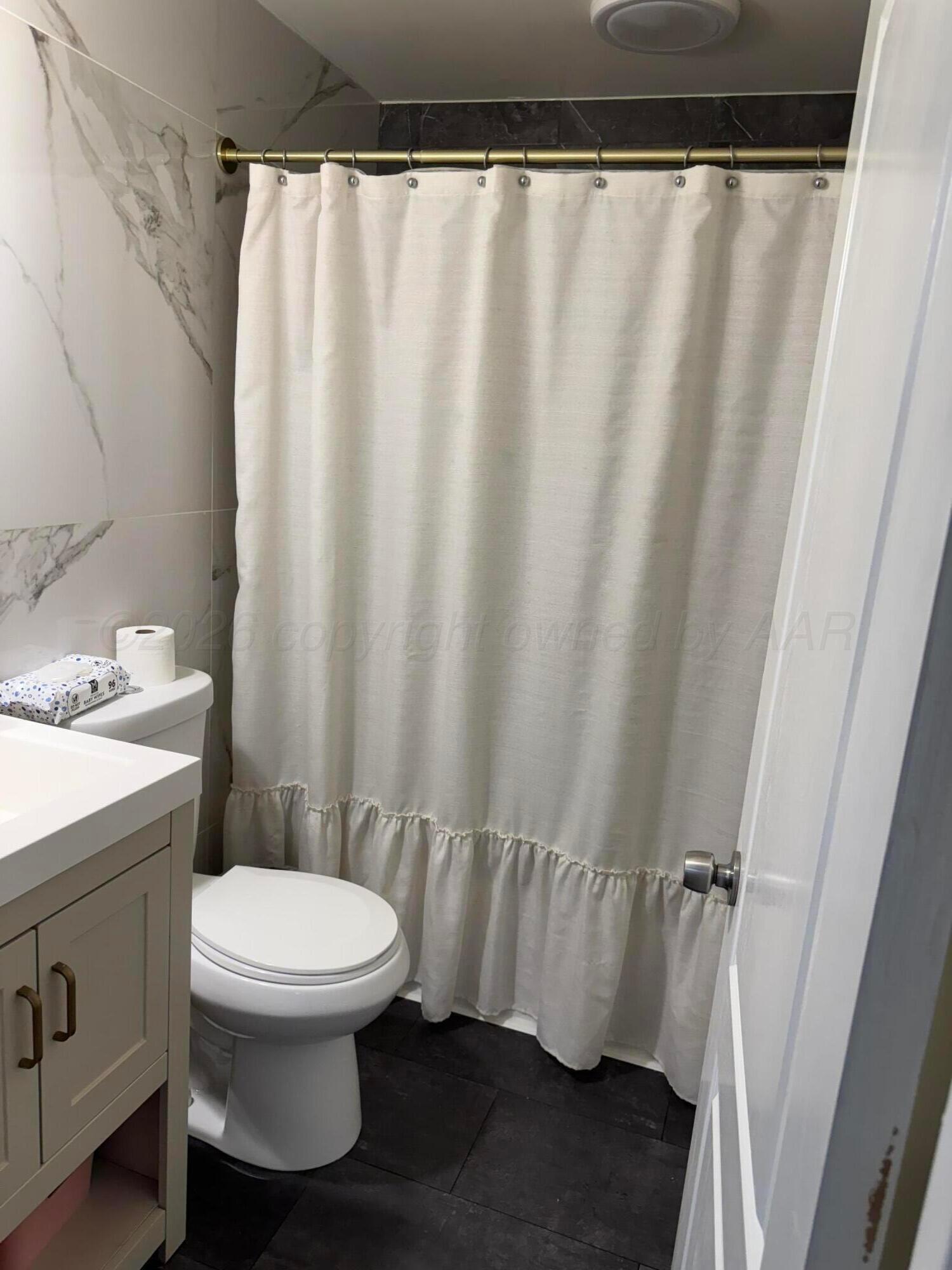 211 South 7th Street Canadian, TX 79014 - Photo 10 of 11 a bathroom with a toilet and a shower curtain
