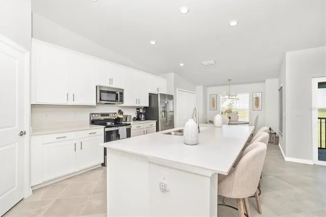 a kitchen with white cabinets and refrigerator