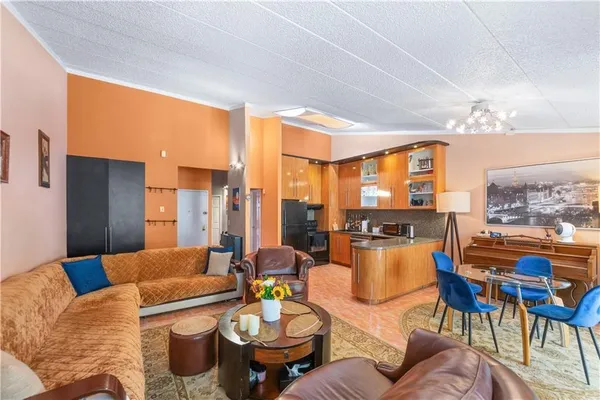 a living room with furniture kitchen view and large windows