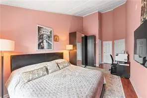 a bedroom with a bed large mirror and a lamp on table