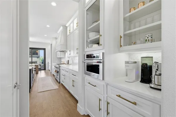a kitchen with stainless steel appliances a refrigerator sink and white cabinets