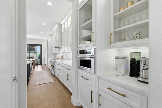 a kitchen with stainless steel appliances a refrigerator sink and white cabinets