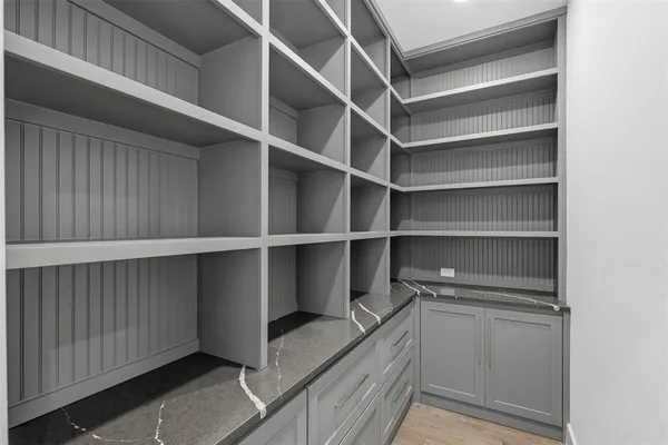 a view of walk in closet with empty racks