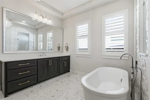 a bathroom with a bathtub sink and mirror