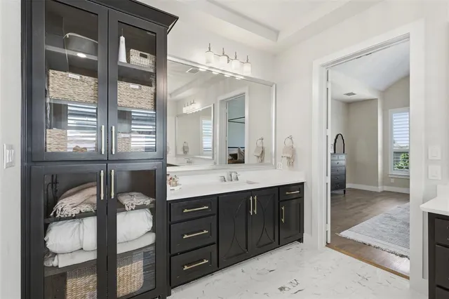 a spacious bathroom with a granite countertop sink and a mirror