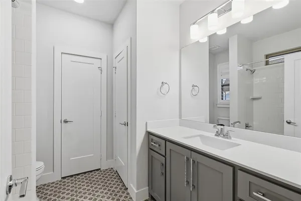 a bathroom with a sink a toilet a shower and a mirror