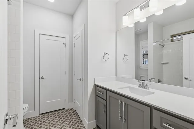 a bathroom with a sink a toilet a shower and a mirror