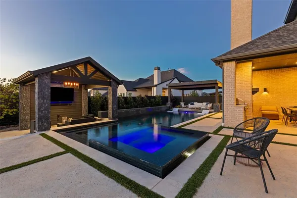 a view of a house with swimming pool and sitting area