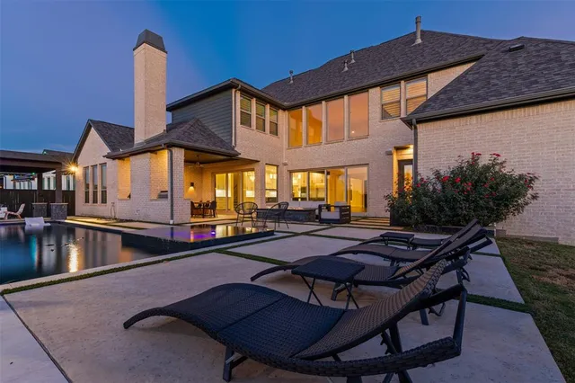 a backyard of a house with swimming pool table and chairs
