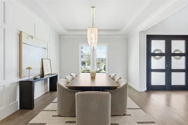 a dining hall with stainless steel appliances granite countertop a stove a refrigerator a sink with a dining table and chairs