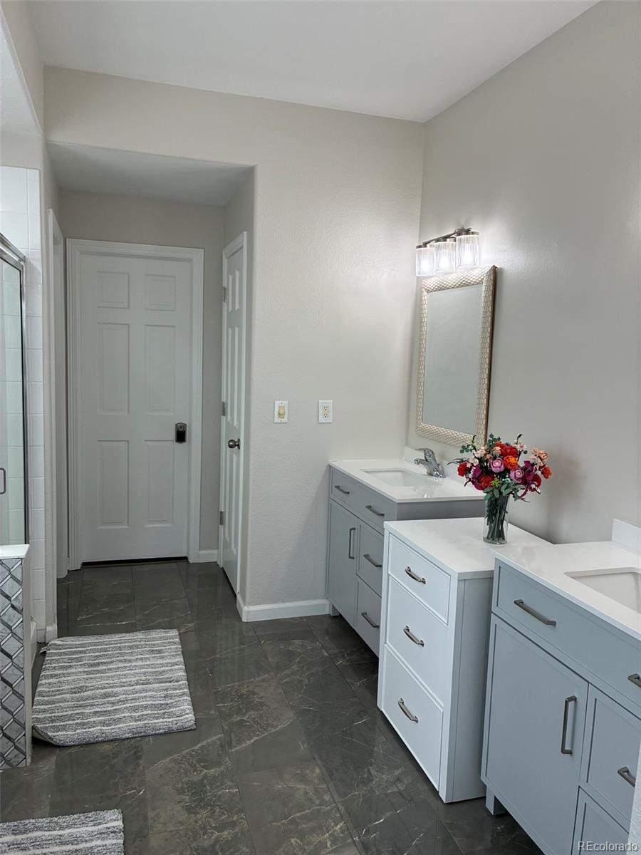 7242 South Rome Street Aurora, CO 80016 - Photo 15 of 33 a bathroom with a sink vanity and mirror
