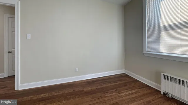a view of a small space with wooden floor and a window