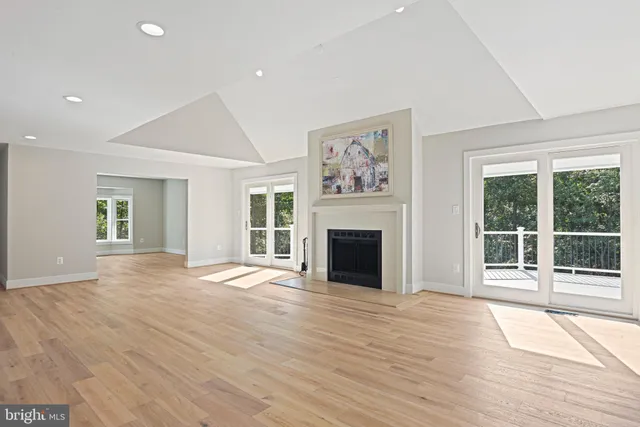 an empty room with wooden floor and window