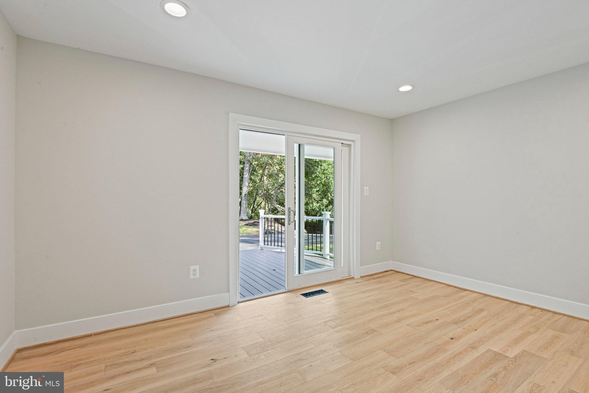 10900 Hunter Station Road Vienna, VA 22181 - Photo 33 of 110 an empty room with wooden floor and sliding door