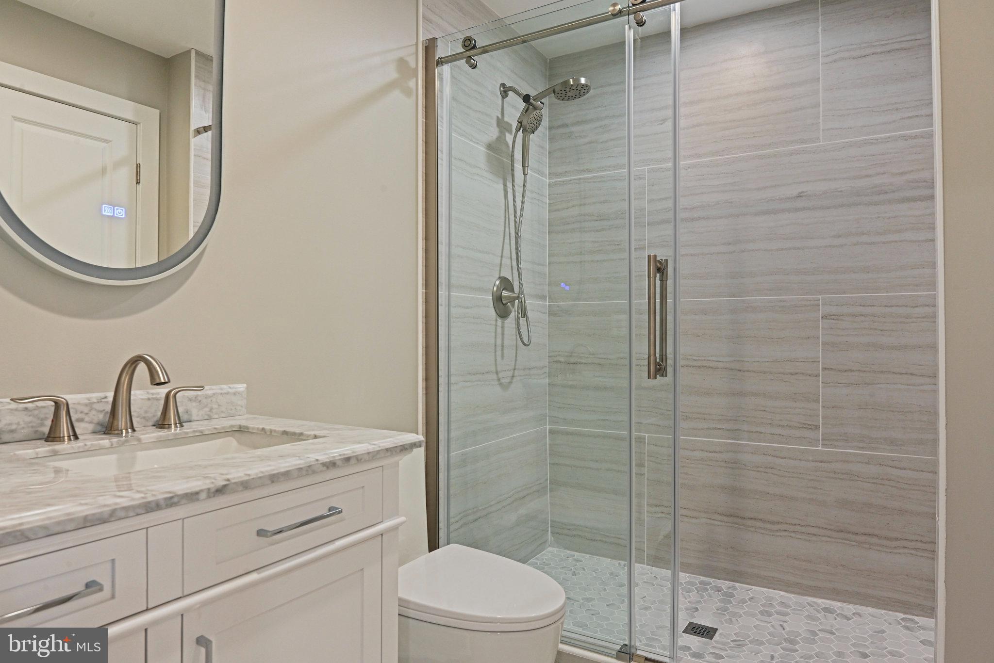 10900 Hunter Station Road Vienna, VA 22181 - Photo 38 of 110 a bathroom with a granite countertop sink a toilet and shower