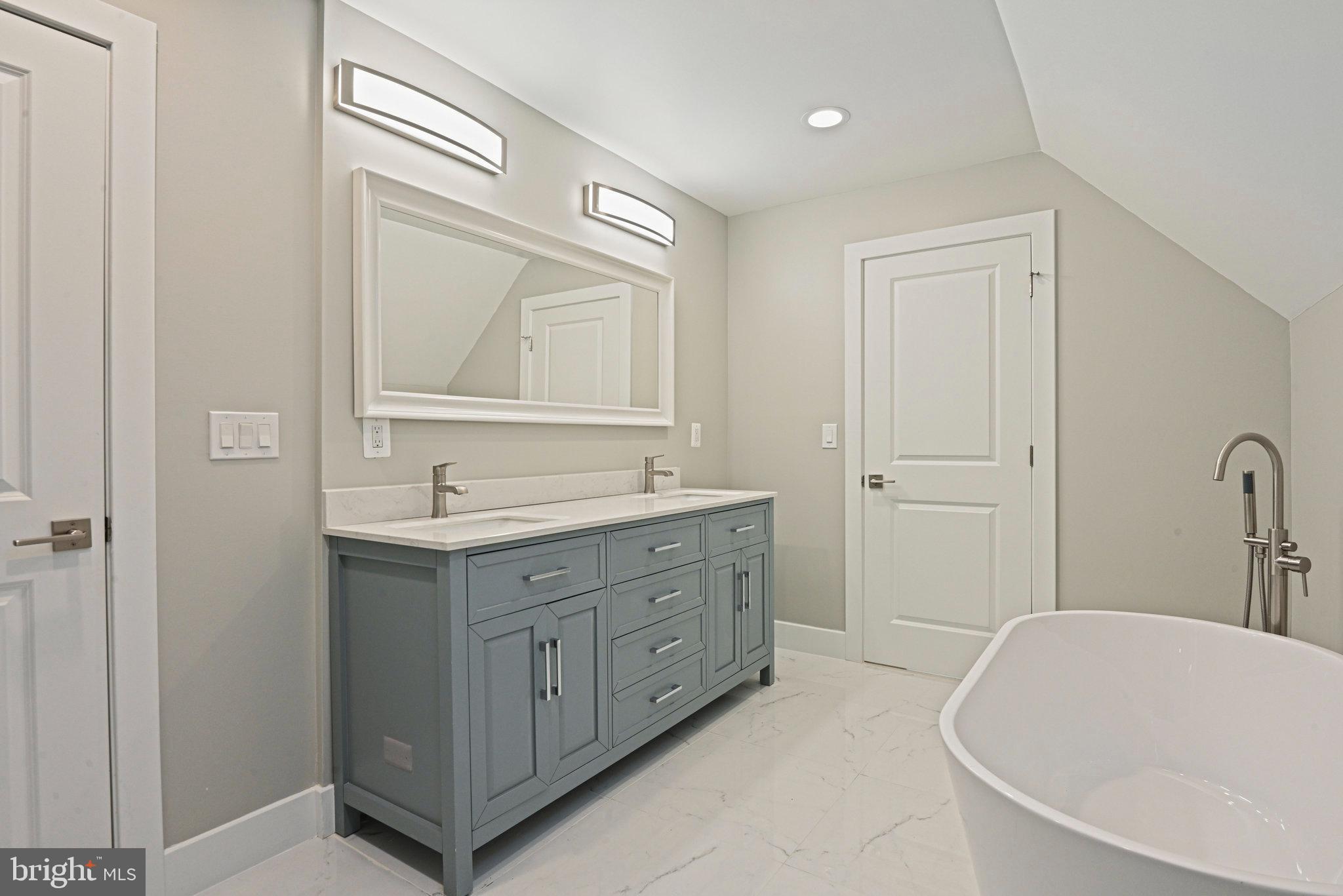 10900 Hunter Station Road Vienna, VA 22181 - Photo 62 of 110 a bathroom with a tub sink and mirror